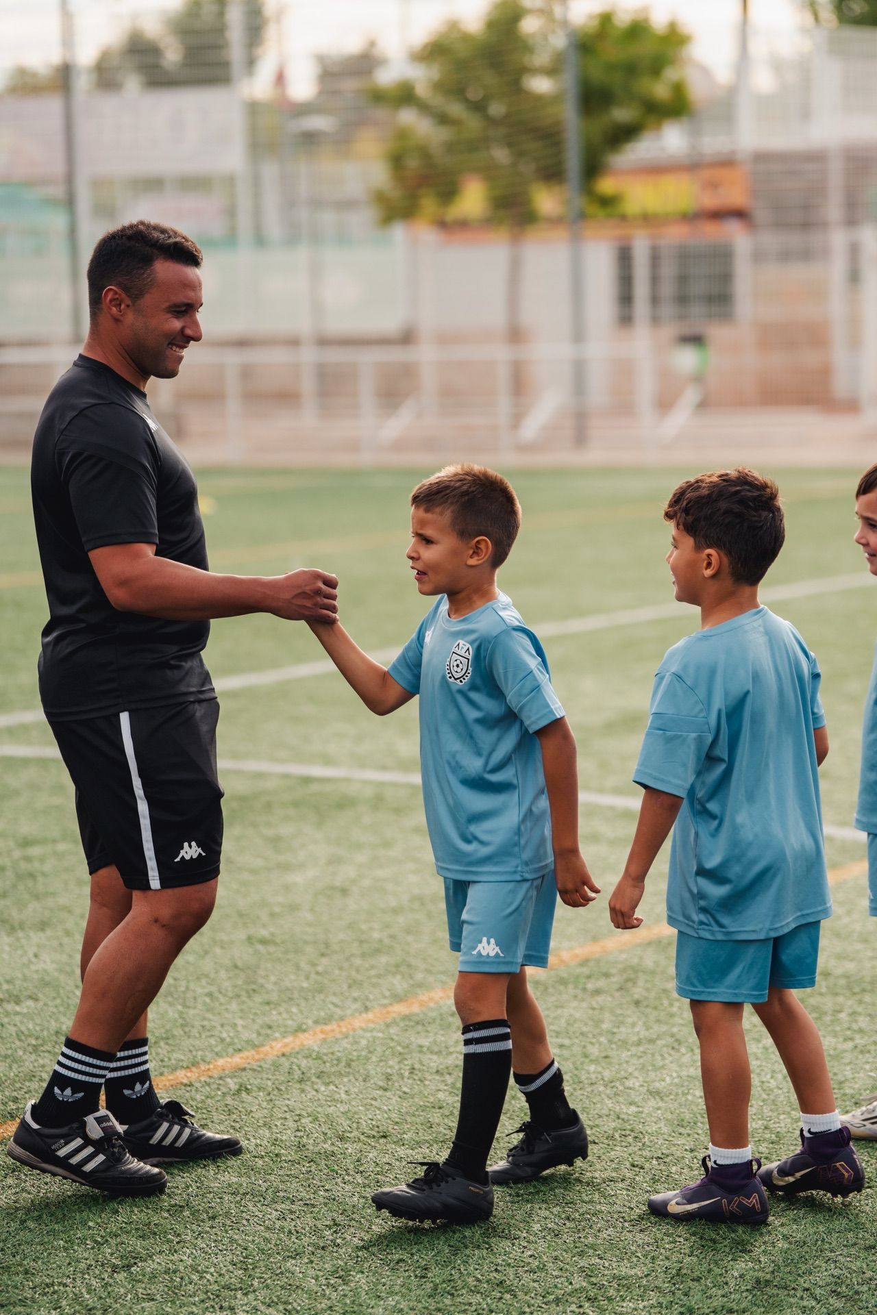 Entrenador saludando a jugador en Campus AFA